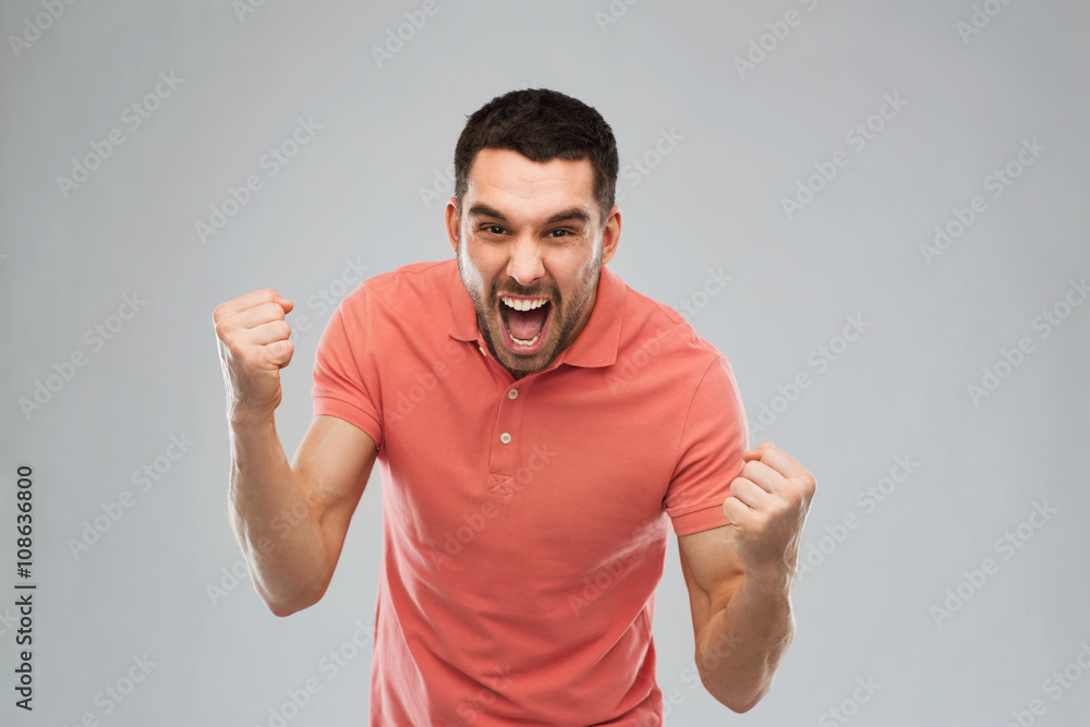 happy man celebrating victory over gray background happy man celebrating victory over gray background
