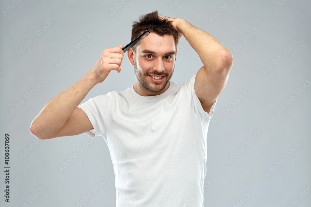 happy man brushing hair with comb over gray happy man brushing hair with comb over gray