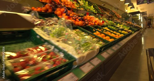 Shopping cart in supermarket among fruit and vegetable. Shopping cart point of view
