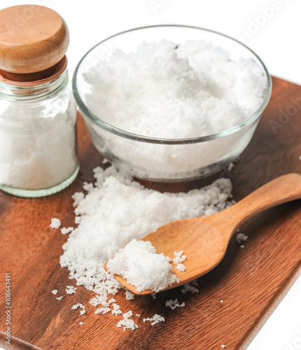 white salt in wooden spoon on wood