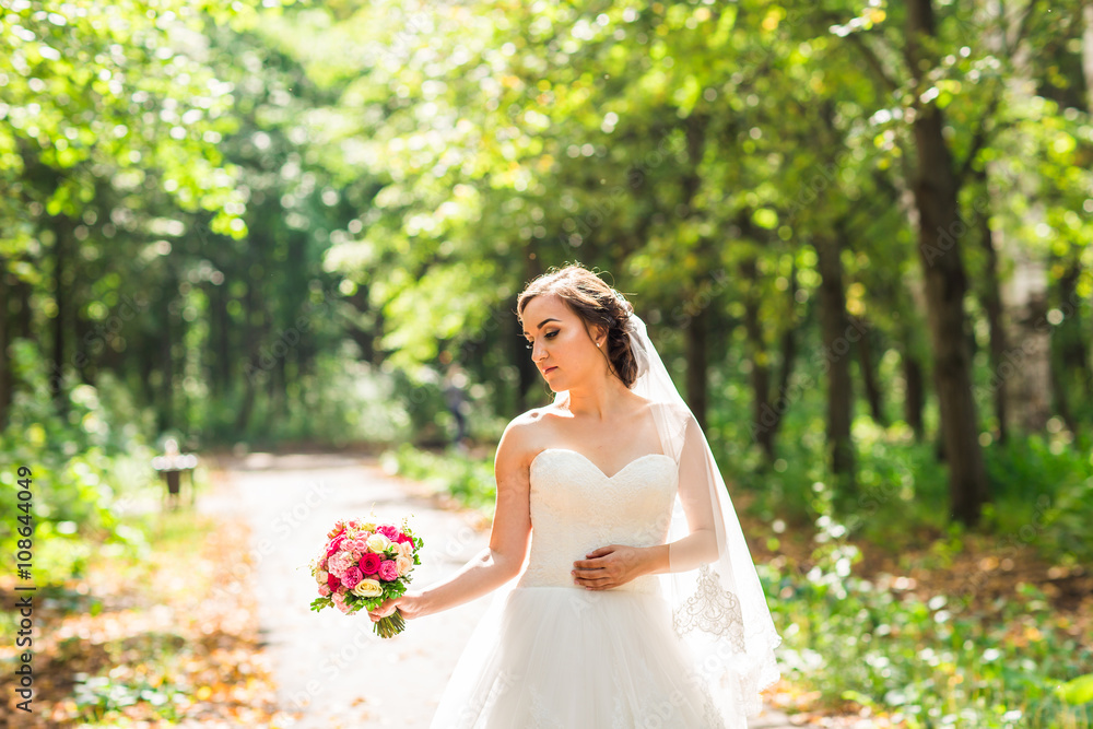 Young bride in wedding dress holding bouquet Young bride in wedding dress holding bouquet