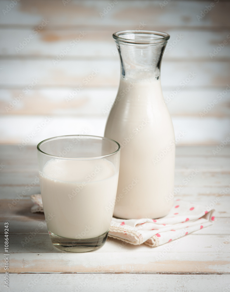 Milk in jar and glass on the old wooden,morning light Milk in jar and glass on the old wooden,morning light