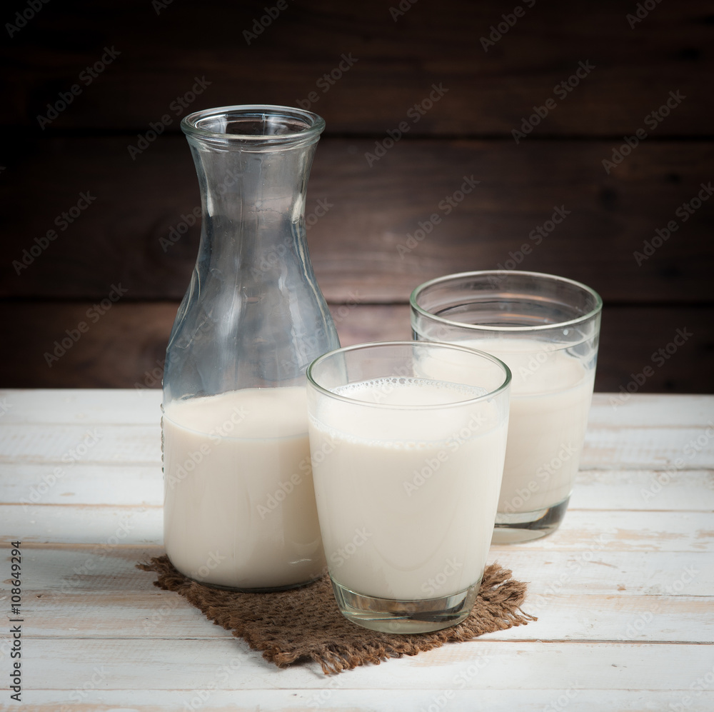 Milk in jar and glass on the old wooden,morning light Milk in jar and glass on the old wooden,morning light