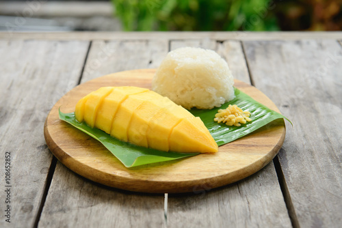 Mango sticky rice on wooden plate
