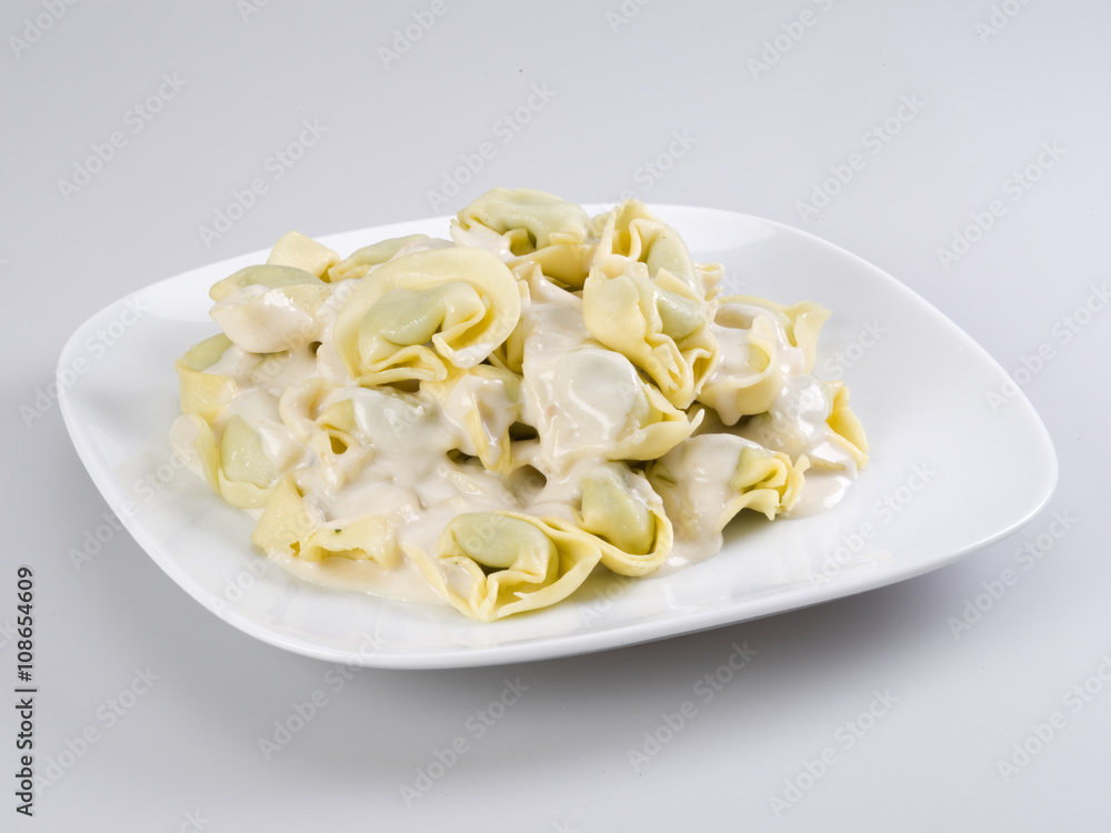 Closeup of a bowl of tortellini stuffed with spinach, four cheese sauce