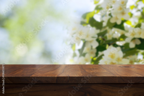 Empty top wooden table and floral blurred background