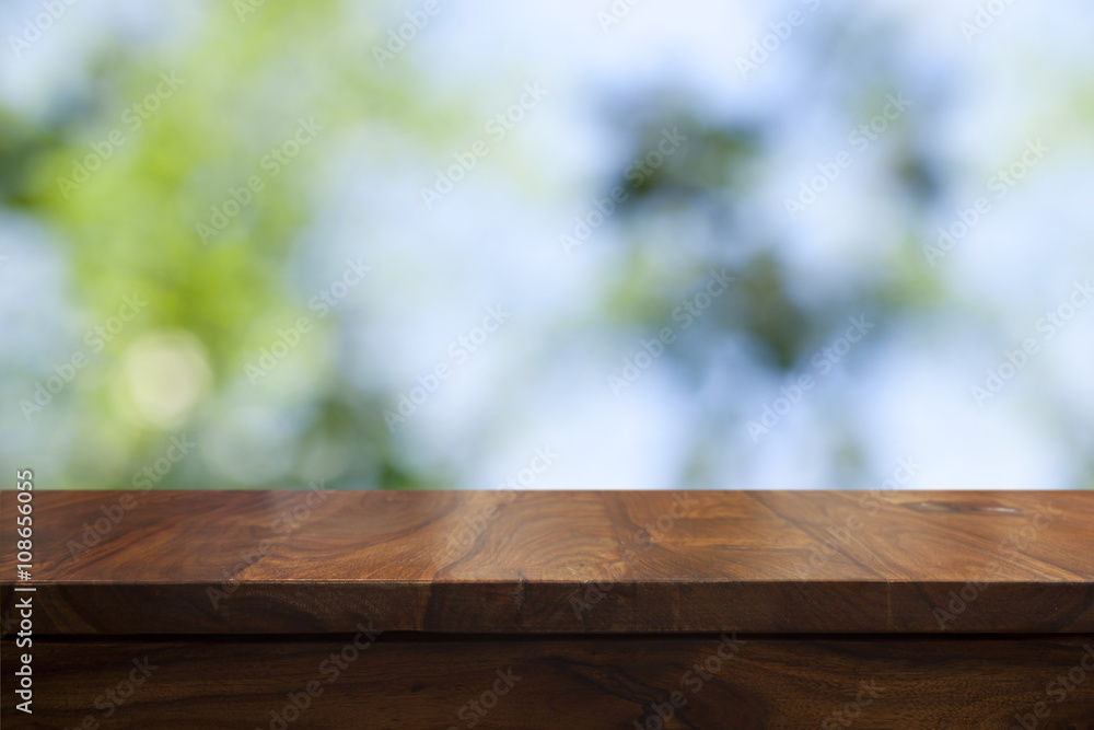 Empty top wooden table and floral blurred background Empty top wooden table and floral blurred background