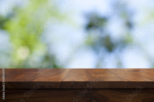 Empty top wooden table and floral blurred background