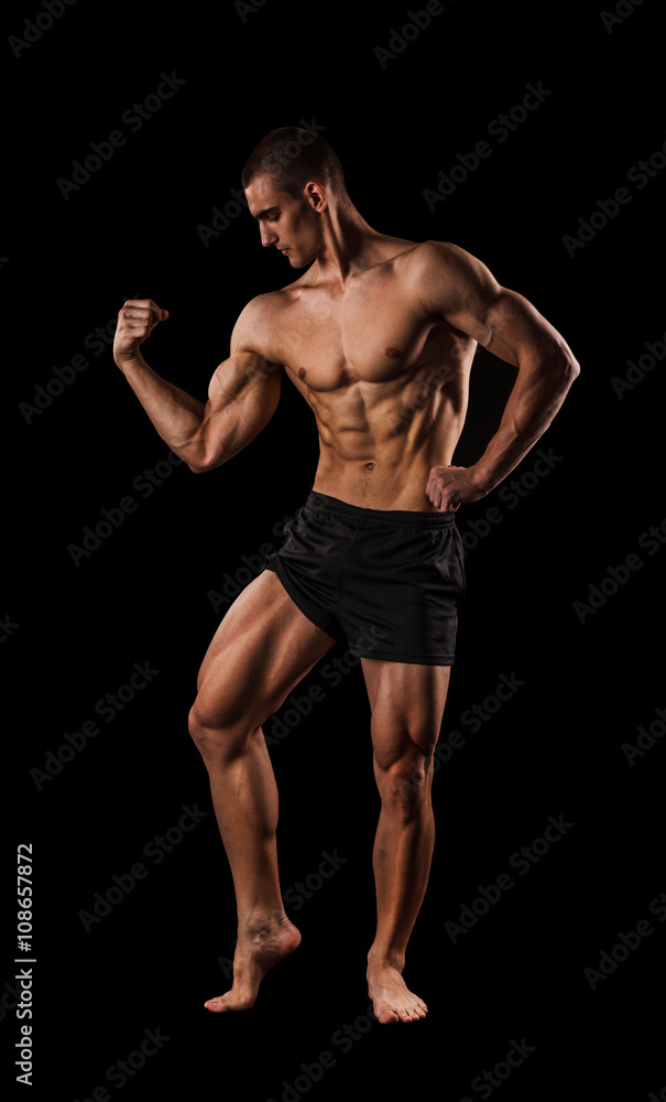 Sexy Athletic Man showing six pack abs. Isolated on black background with copy space Sexy Athletic Man showing six pack abs. Isolated on black background with copy space