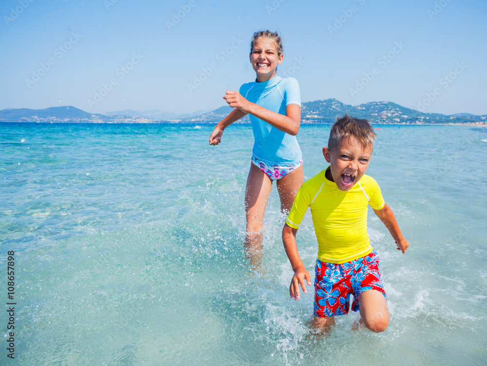 Fototapeta premium Two happy kids playing on the beach