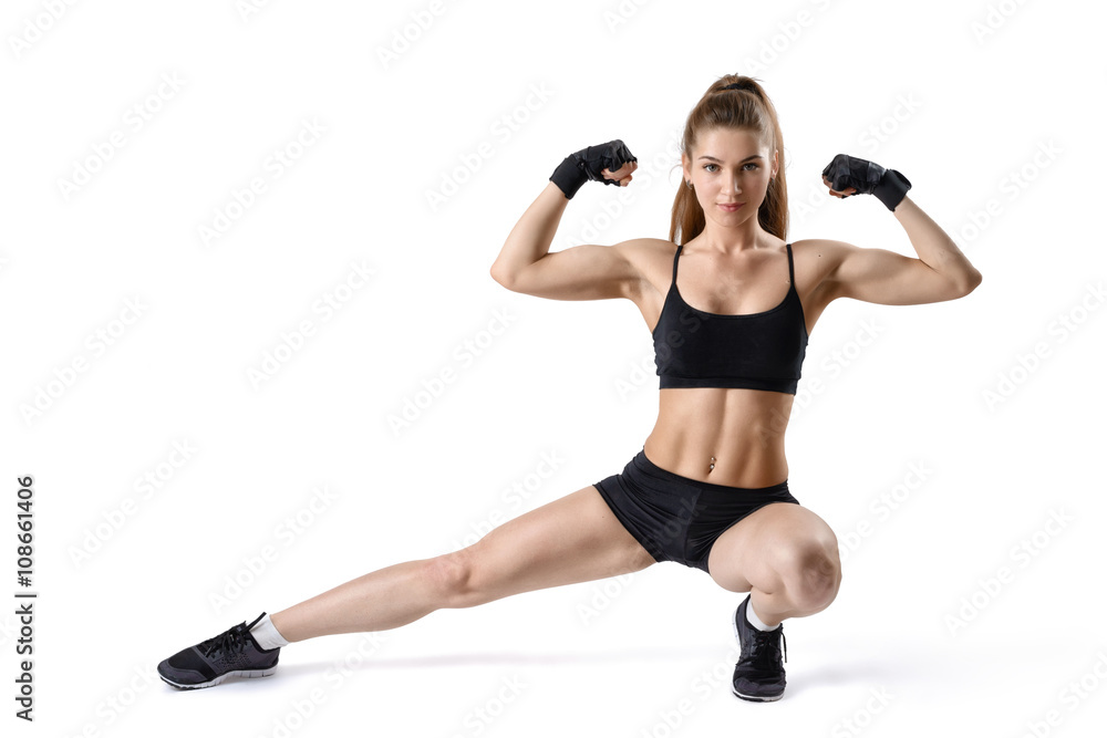 Portrait of strong muscular woman flexing her biceps and stretching leg. Cutout fitness girl.