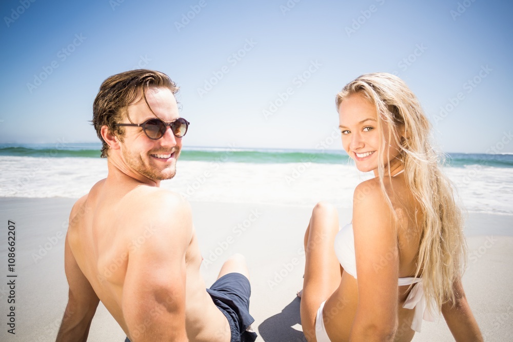 Happy couple sitting on the beach
