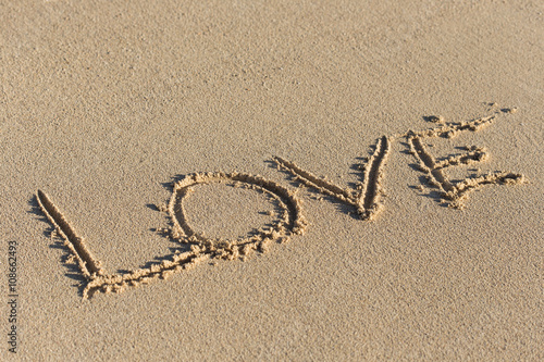 Inscription Love on sandy beach