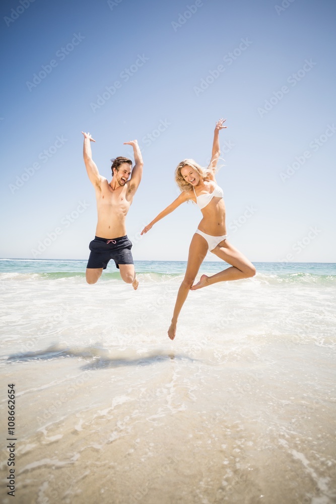 Happy couple jumping on the beach Happy couple jumping on the beach