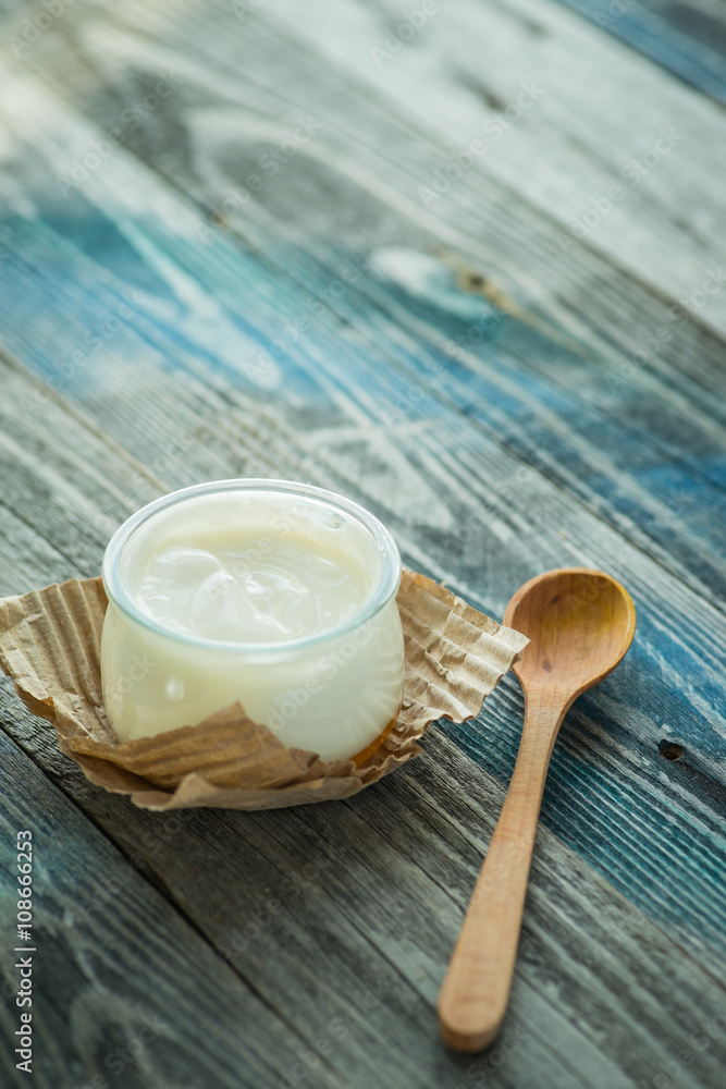Jar with fresh yogurt on a rustic table Jar with fresh yogurt on a rustic table