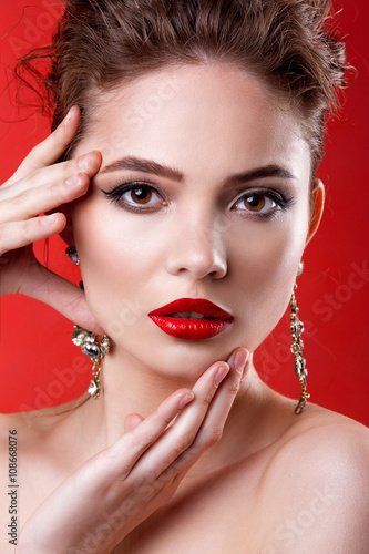 Beautiful model girl on a red background . The beauty of a woman