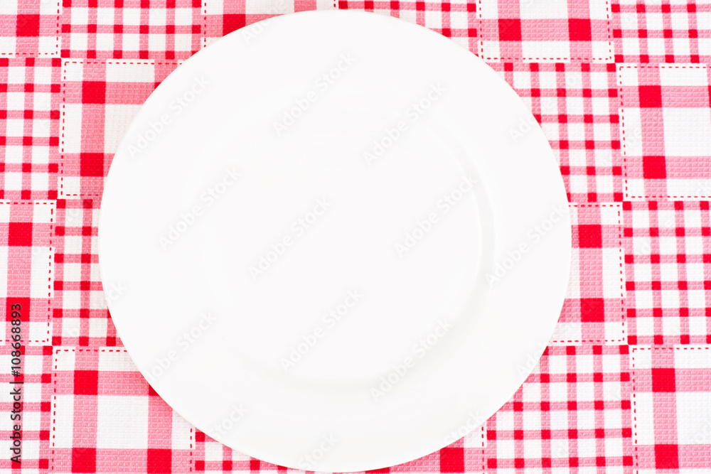 White Plate on a Checkered Tablecloth with Place for Your Text White Plate on a Checkered Tablecloth with Place for Your Text