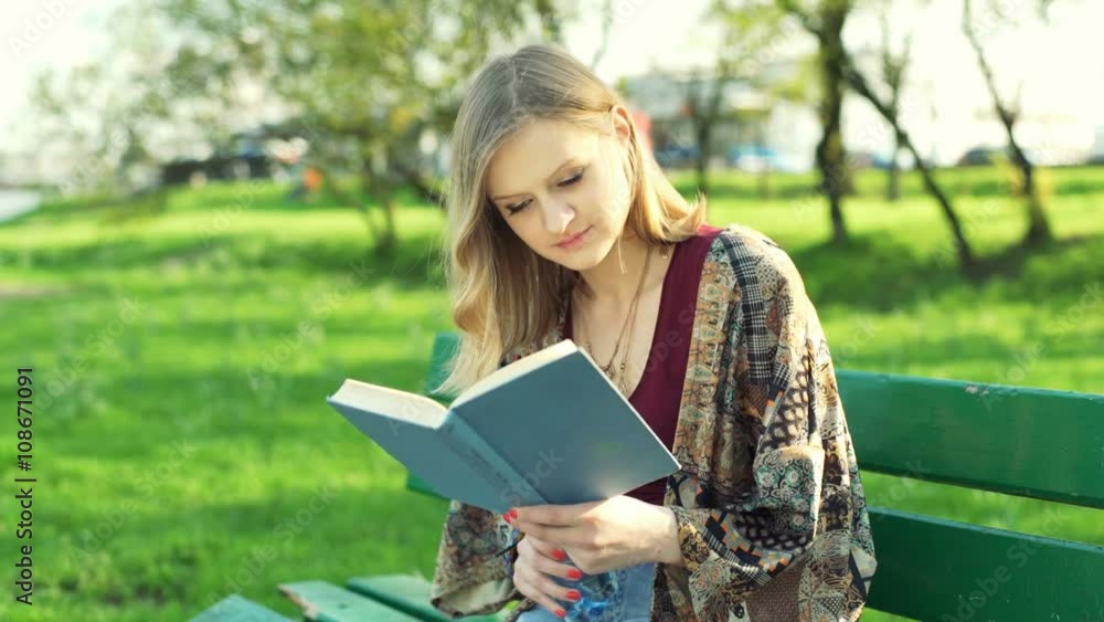 Girl reading book and drinking water in the park
Girl reading book and drinking water in the park