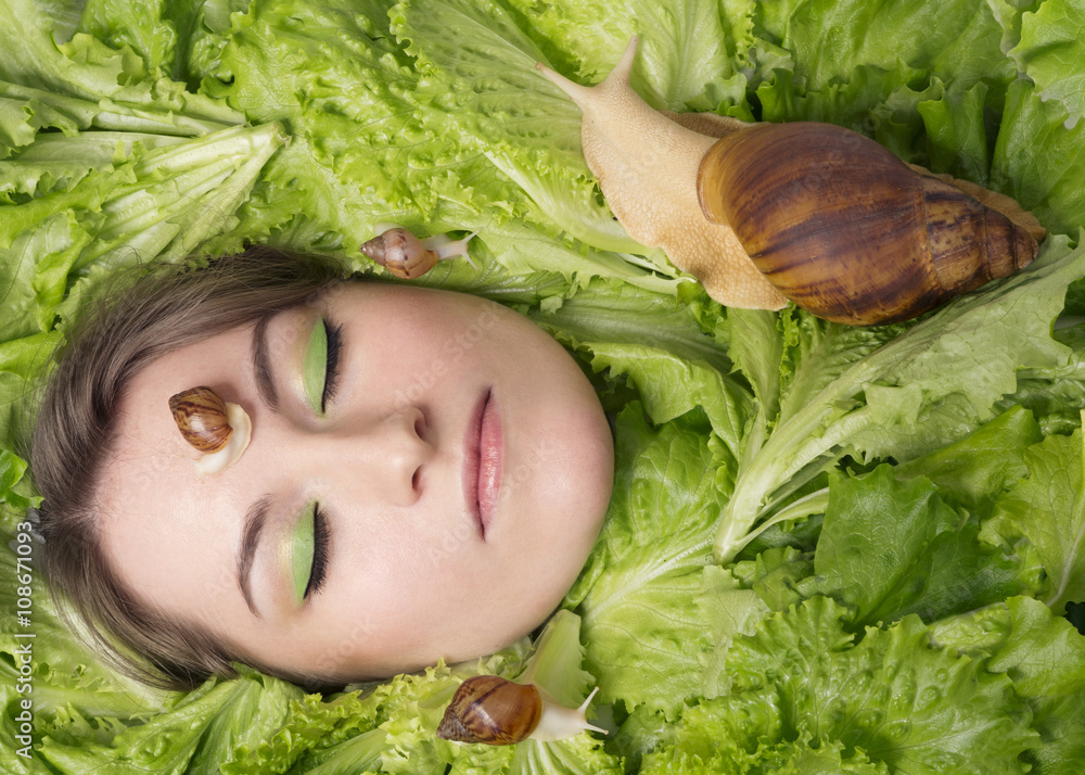 young woman and albino Achatina snails among lettuce young woman and albino Achatina snails among lettuce