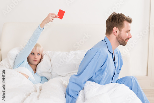 Fotografie Woman Showing Red Card To Man In Bed