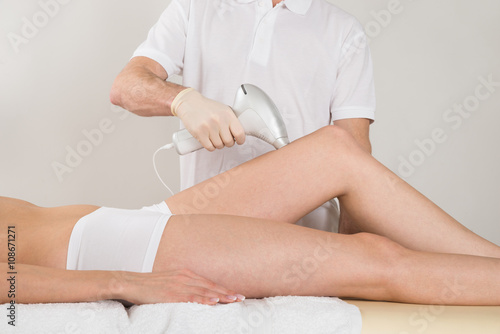 Woman Receiving Epilation Treatment On Legs At Spa