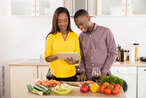 Happy Young Couple Standing In Kitchen