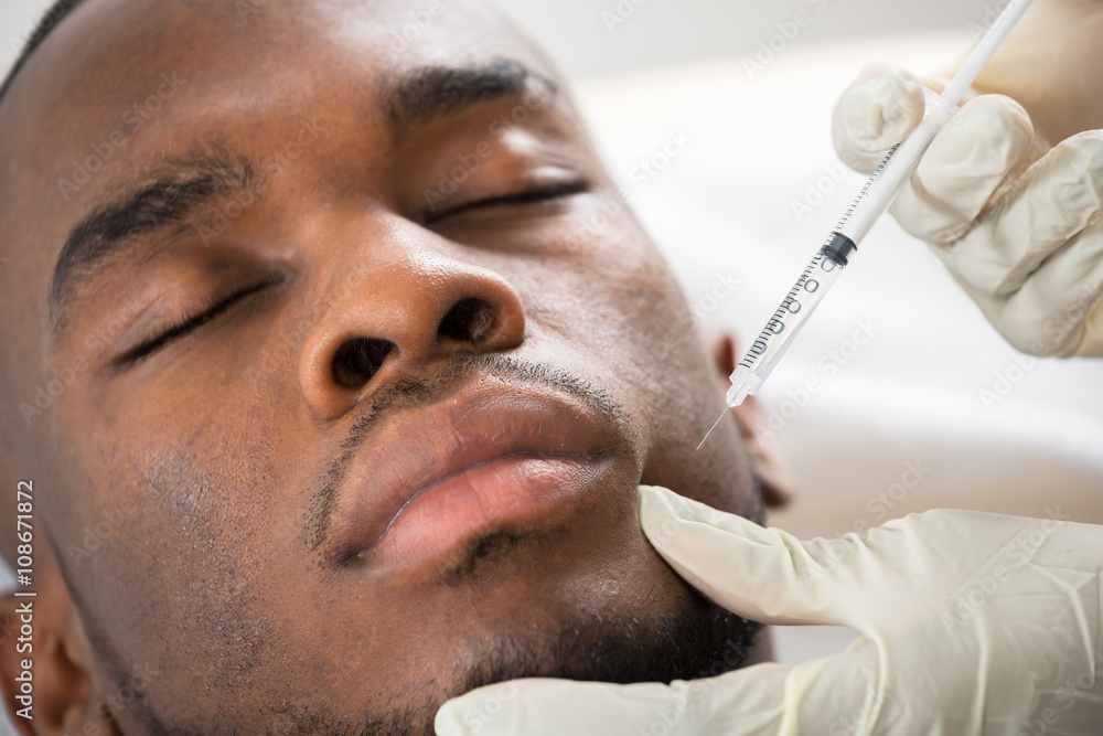 Person Hand Injecting Syringe On Young Man Face Person Hand Injecting Syringe On Young Man Face