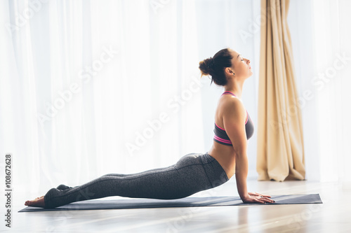 Urdhva mukha svanasana. Beautiful yoga woman practice in a training hall background. Yoga concept.
