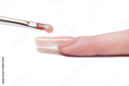Professional manicurist applying liquid acrylic to nail extensions. macro  