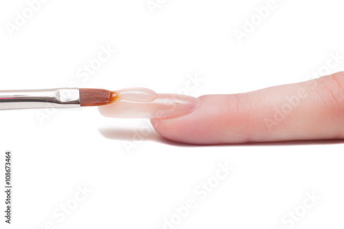 Professional manicurist applying liquid acrylic to nail extensions. macro
 photo