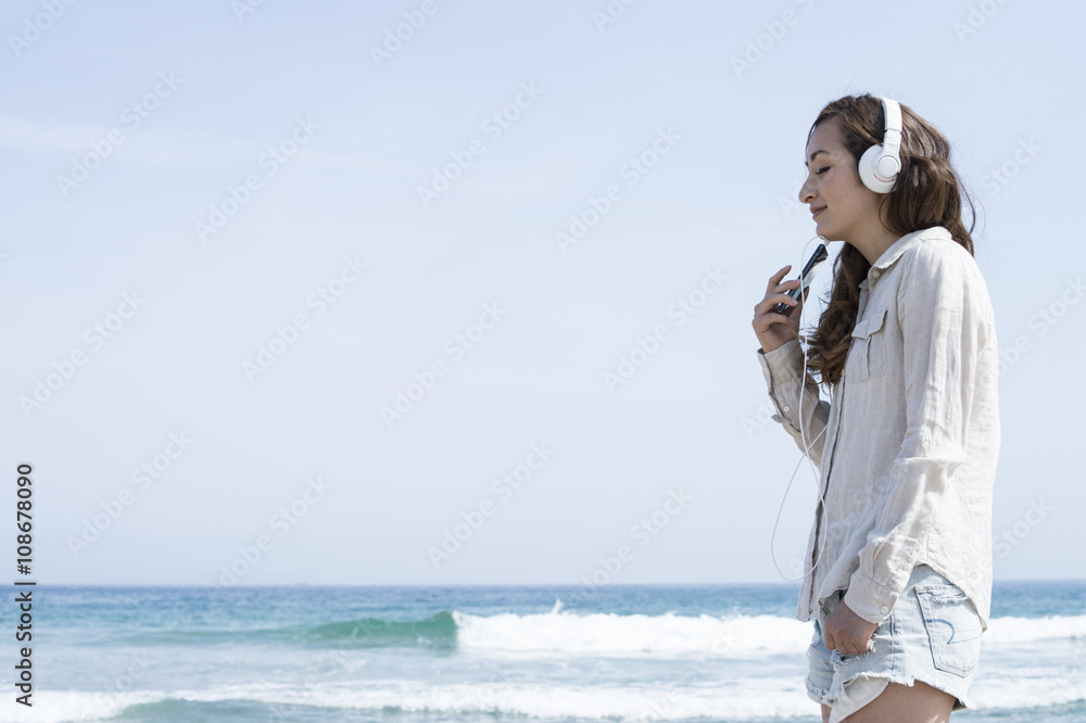 Women have to relax and listen to music at the beach