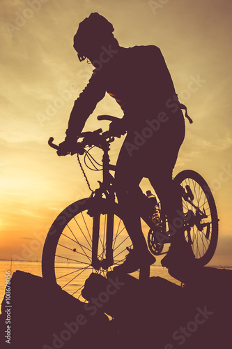 Fototapeta Naklejka Na Ścianę i Meble -  Healthy lifestyle. Silhouette of bicyclist riding the bike at seaside
