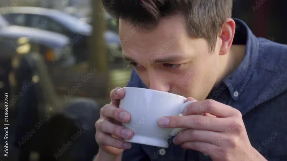 Handsome Young Man takes sip of coffee, nods, smiles, and laughs Handsome Young Man takes sip of coffee, nods, smiles, and laughs