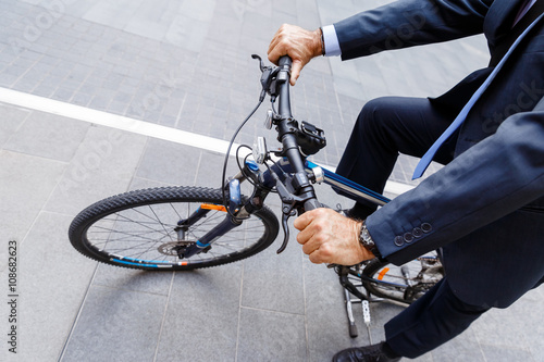 Successful businessman riding bicycle