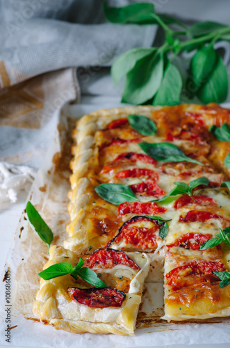 pie of puff pastry with tomato, mozzarella and pesto sauce