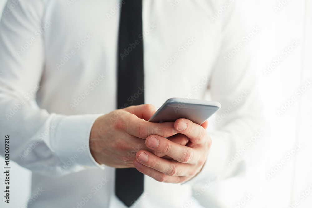 Man holding a smartphone and writing Man holding a smartphone and writing