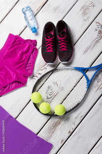 Dark sneakers and tennis racquet.