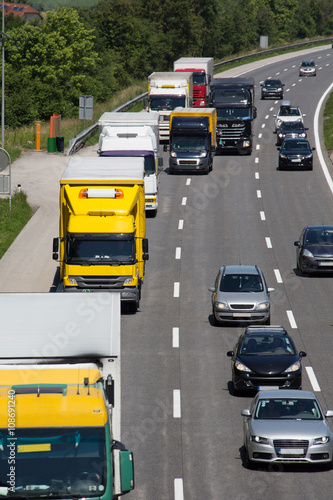 Lastwagen überholen auf Autobahn. LKW zahlen Mautgebühr beim Transport von Gütern. Infrastruktur durch ausreichende Autobahnen und Straßen sichern Verkehr.