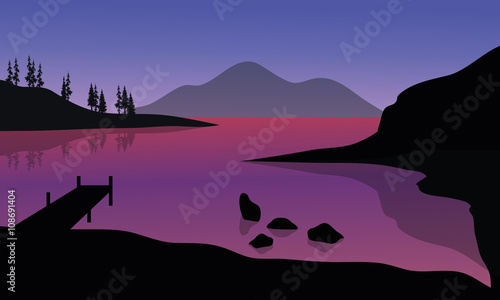 Silhouette of pier and mountain in sea