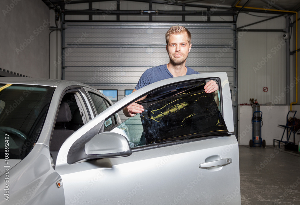 Applying tinting foil onto a car window Applying tinting foil onto a car window