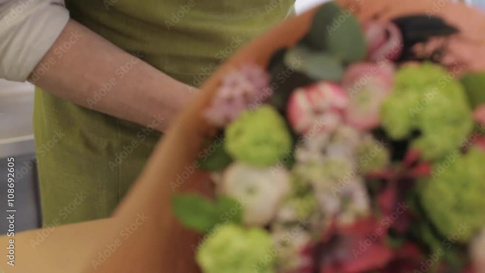 florist wrapping flowers in paper at flower shop florist wrapping flowers in paper at flower shop