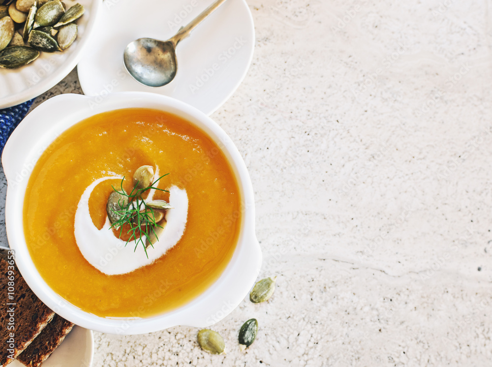 Curried carrot soup with cream and seeds on marble table. Selective focus. Curried carrot soup with cream and seeds on marble table. Selective focus.