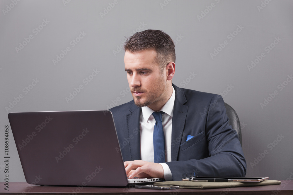 Handsome business man working with laptop in office Handsome business man working with laptop in office