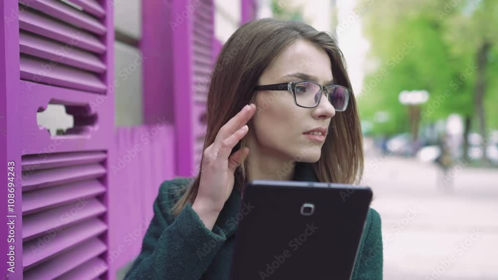 Portrait of young woman using a tablet on a street 4k Portrait of young woman using a tablet on a street 4k