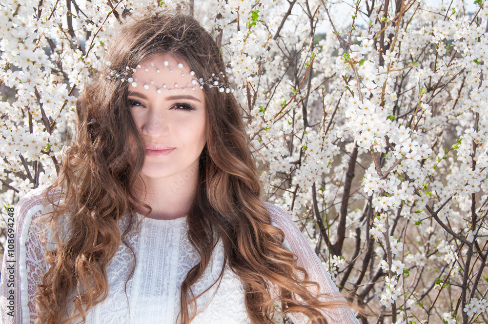 Portrait of young woman in the flowered garden in the springtime. Tender and beautiful posing. Portrait of young woman in the flowered garden in the springtime. Tender and beautiful posing.