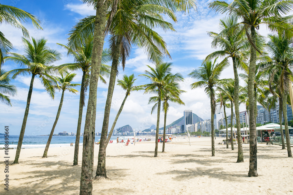 Scenic view of Copacabana Beach through palm trees from the Leme neighborhood in Rio de Janeiro, Brazil Scenic view of Copacabana Beach through palm trees from the Leme neighborhood in Rio de Janeiro, Brazil