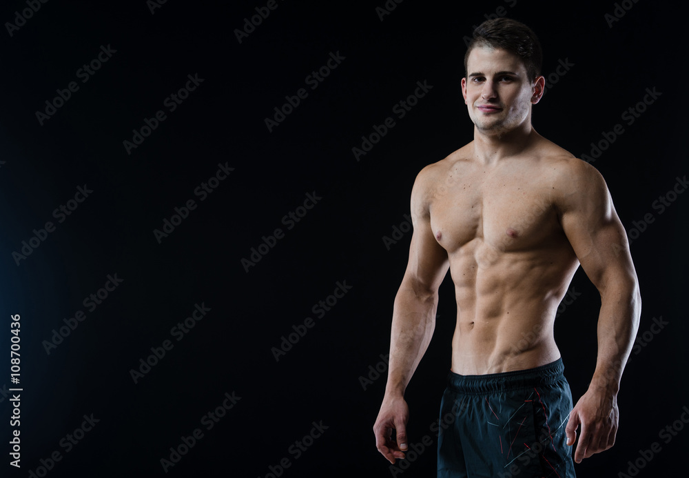 Young and fit male model posing his muscles looking straight to camera Young and fit male model posing his muscles looking straight to camera