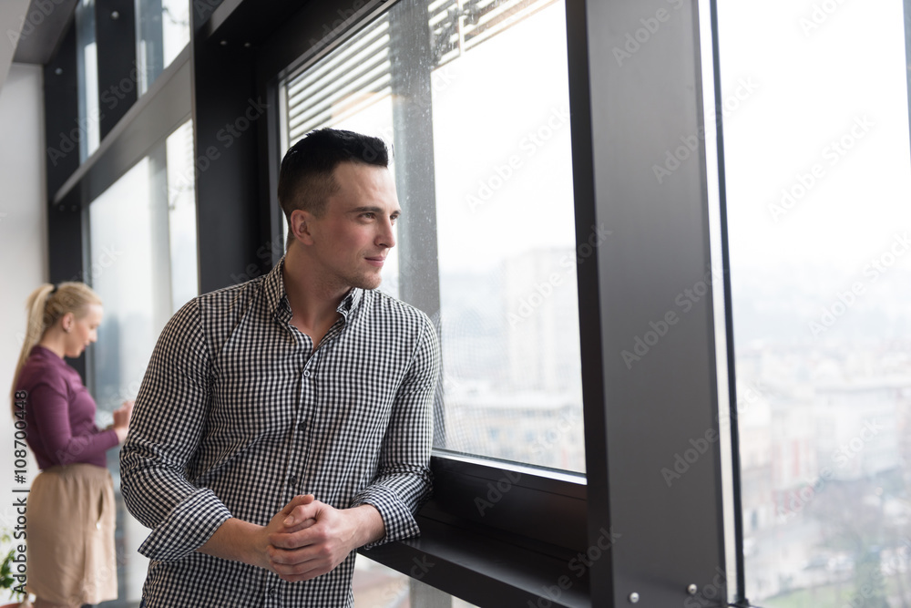 business man at office looking through window business man at office looking through window