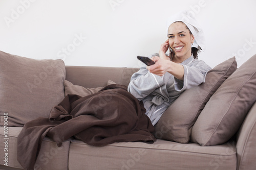 Portrait Of Young Woman Sitting On Couch Watching Television