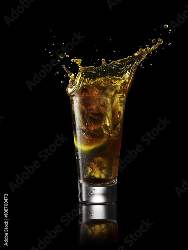 Splash in alcoholic drink on black background